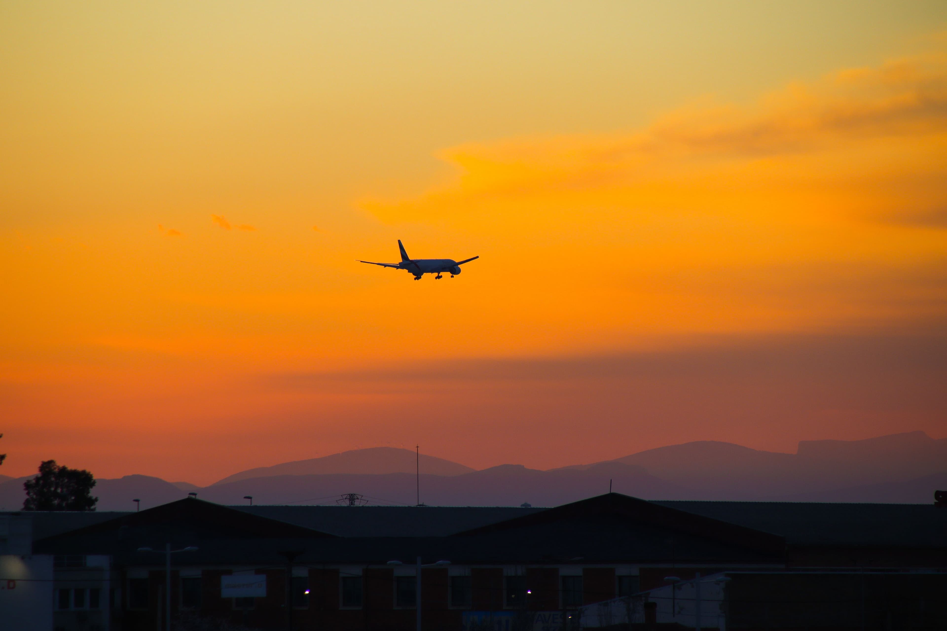 Aircraft descending into a sunset sky